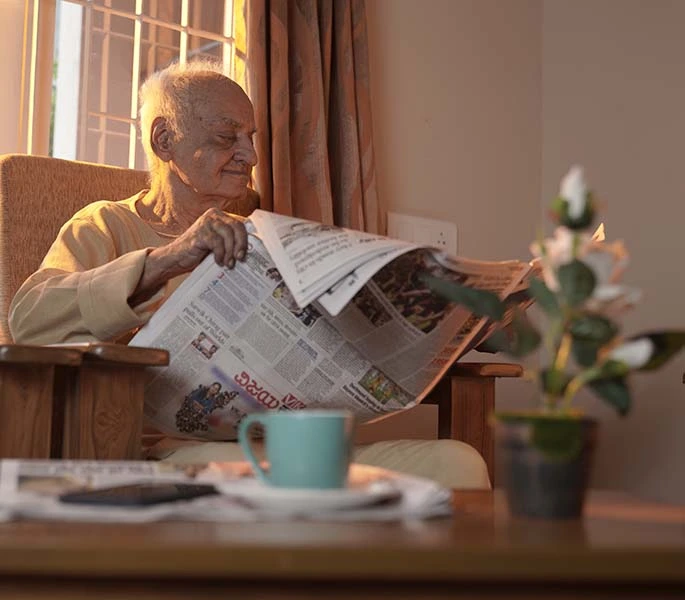 elder man reading newspaper